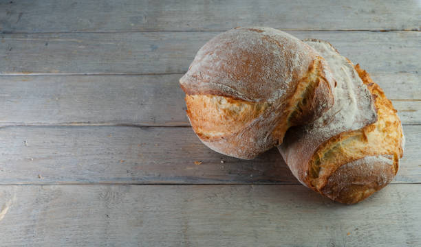 istock Rustic bread, crusty loaf, close-up, wooden background. 1472387471