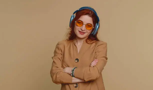 Photo of Young happy woman in headphones listening music dancing disco having fun relaxing on christmas party