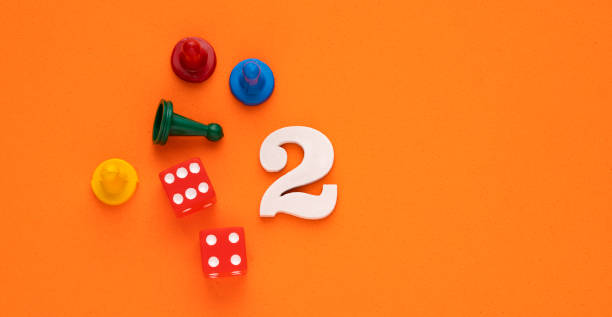 istock Number 2 with dice and board game pieces - Orange eva rubber background 1472396990