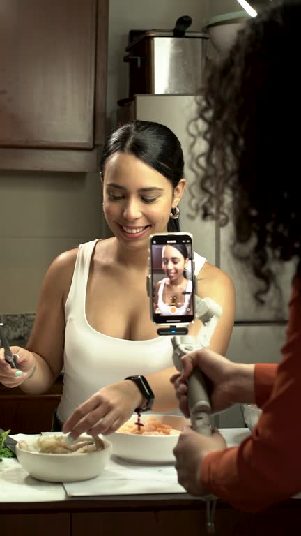 Latin woman Vlogger is in the kitchen of her house with the help of her assistant, she records a video of recipes for her followers