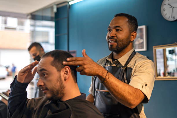 istock Barber shop worker preparing his customer for a haircut. 1472399363