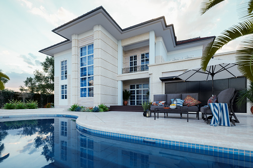 Luxury villa with swimming pool and patio furniture.