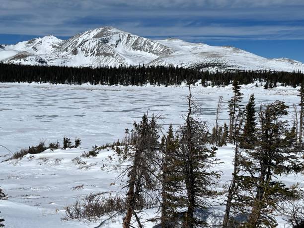 istock Frozen lake surrounded by snow-capped peaks 1472420030