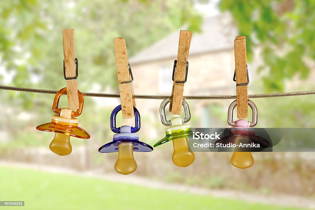 Pacifiers in line Colored baby pacifiers hanging outside in line Pacifier Stock Photo