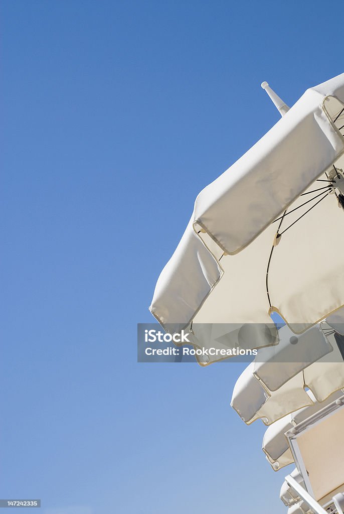 White sun umbrellas Line of white sun umbrellas on a clean blue sky Beach Stock Photo