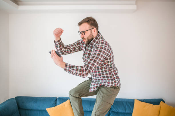 istock Excited man jumps for joy while using mobile phone for online gambling and wins 1472432380