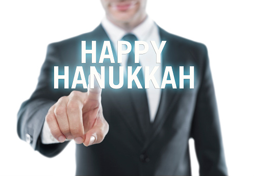 Businessman touching “Happy Hanukkah” message on virtual screen.