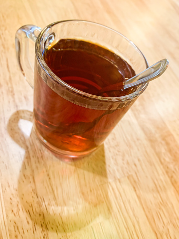 A glass of tea on wooden table top