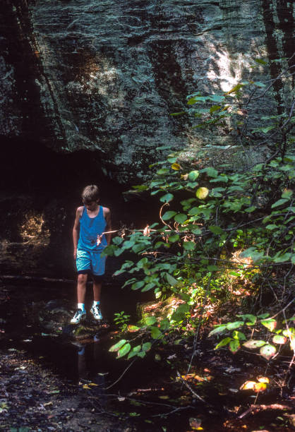 istock Graham Cave SP - Boy Explores Dry Waterfall - 1998 1472435493