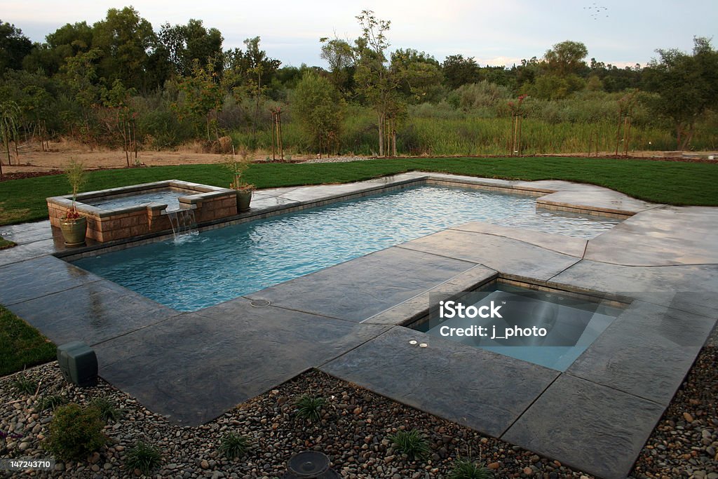 Pool and Spa WIth A View Pool and Spa with a decorative spillover surrounded by beautiful landscaping Swimming Pool Stock Photo