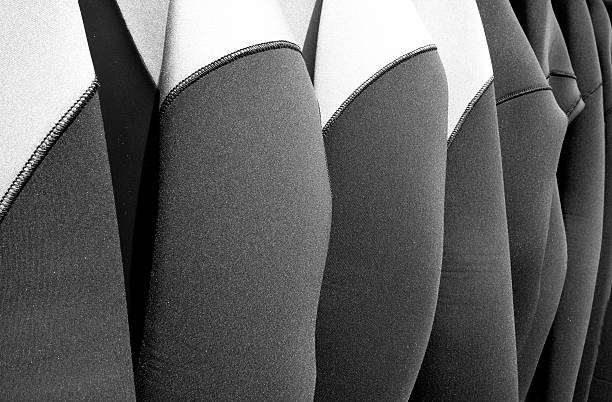 Hanging wetsuits stock photo