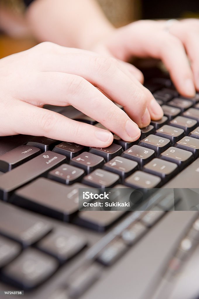 Woman working on PC keyboard and mouse. Young female hands on a computer keyboard, typing. Adult Stock Photo