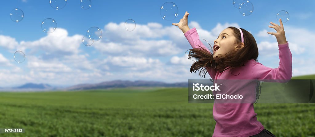 Girl playing with soap bubbles Girl playing with soap bubbles in the field Bubble Stock Photo