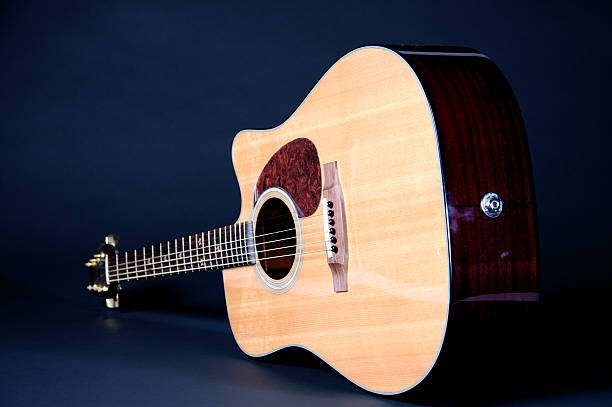istock Acoustic Guitar Isolated On Blue Black Background 147244232
