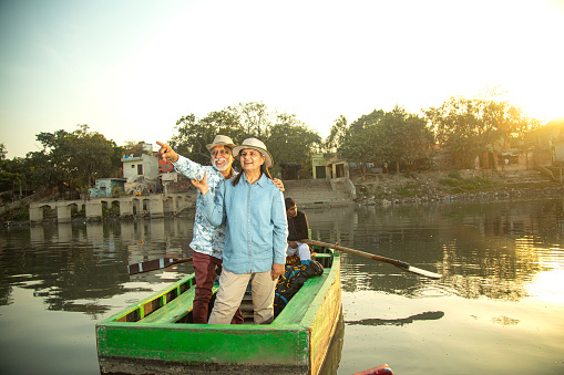 Carefree senior couple tourist traveling on sailboat at lake with their arms around