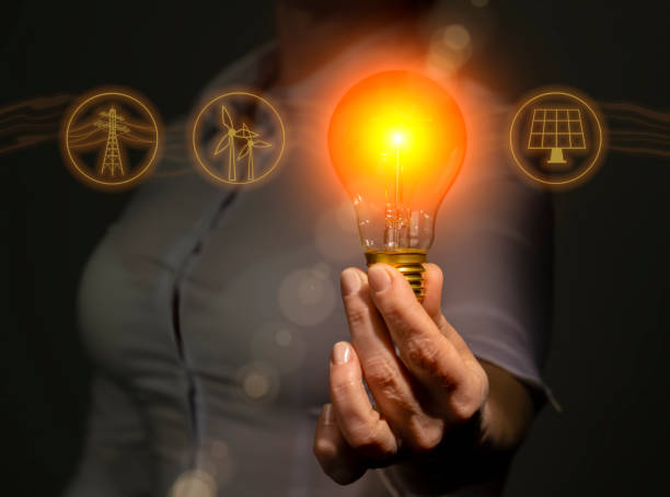 istock Electricity energy sources concept, power industry, hand holding light bulb with electricity extraction icons. 1472447372