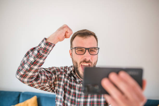 istock Man rejoices because he wins during online gambling 1472448658
