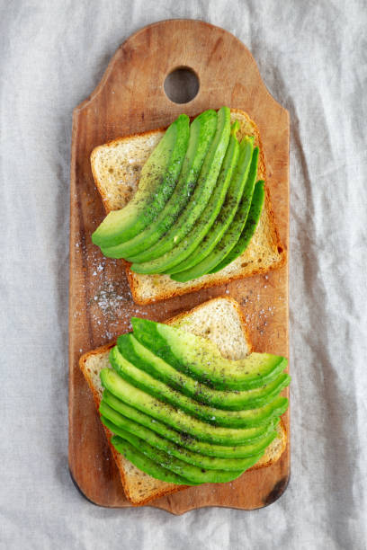 istock Homemade Avocado Toast on a rustic wooden board, top view. 1472448810