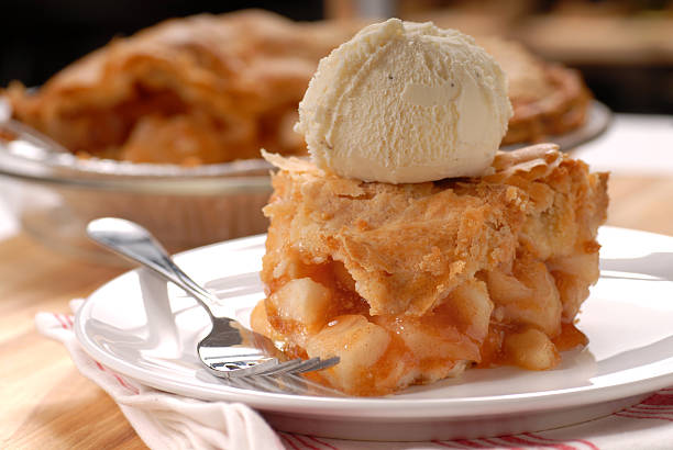 Piece of apple pie with vanilla ice cream A piece of freshly made deep dish apple pie with a flaky crust and vanilla ice cream apple pie and ice cream stock pictures, royalty-free photos & images