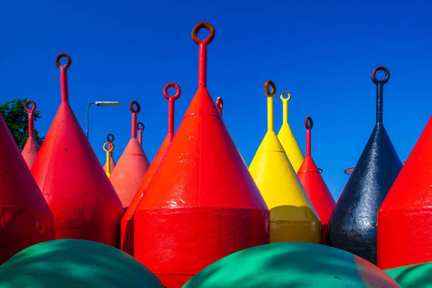 Red and yellow buoys at land of Terschelling. A buoy is a floating device that can have many purposes. It can be anchored (stationary) or allowed to drift with ocean currents.