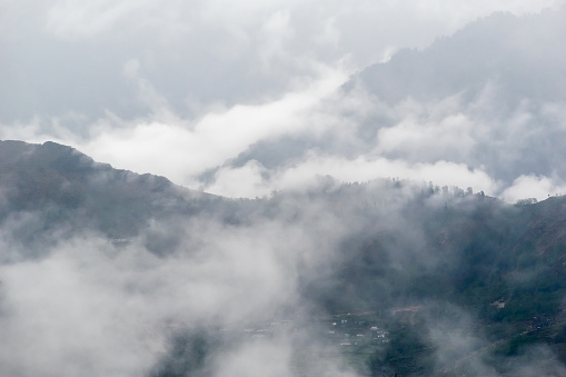 Mist and fog enveloping hills in the Himalayan village of Munsyari in Uttarakhand.