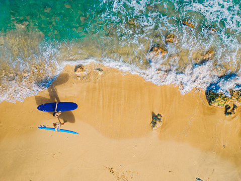 drone point of view 2 asian chinese female surfer walking along beach