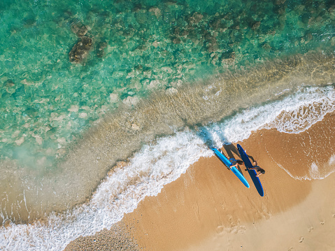 drone point of view 2 asian chinese female surfer walking along beach