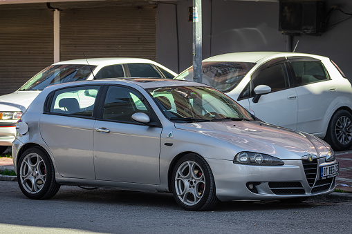 Side, Turkey – February 05 2023: white Alfa Romeo  147  is parked  on the street on a warm day