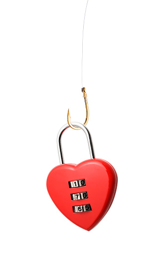 Close-up of heart shaped combination lock with fishing hook against white background.
Fishing for love concept.