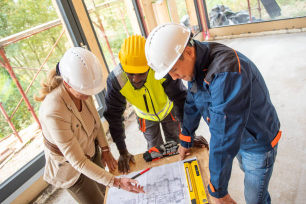 istock Foreperson and building contractors discussing blueprint 1472461001