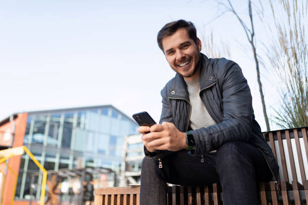 istock young man in jacket with phone outside 1472463860