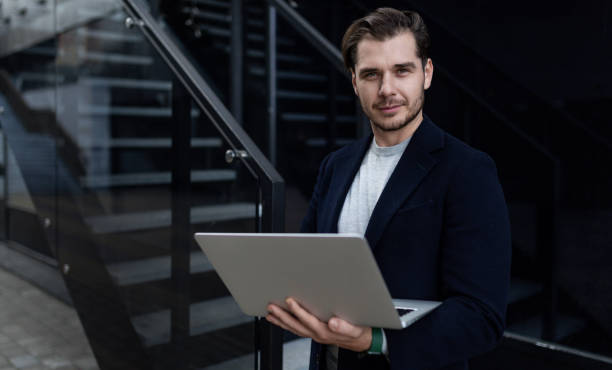 istock business man with a laptop in his hands outside 1472463896