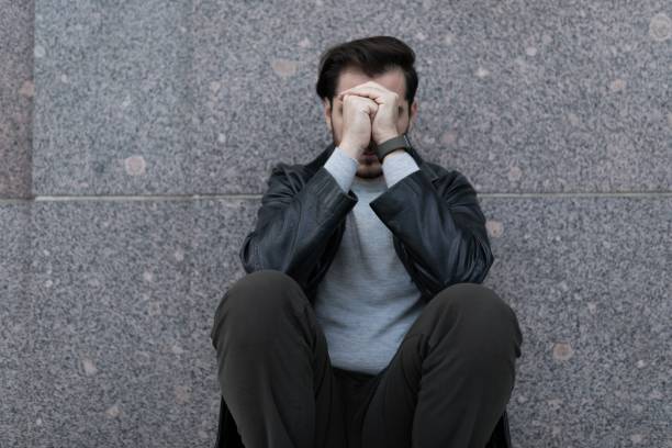 istock grieving man sitting upset covering his face with his hands 1472463957