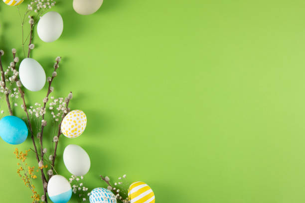 Flowers and Coloured Easter Eggs on Light Green Background