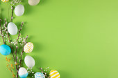 Flowers and Coloured Easter Eggs on Light Green Background