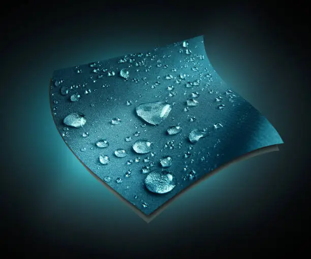 Raindrops on blue technological waterproof and breathable fabric on black background