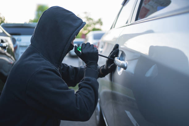 istock The thief is stealing a car with a screwdriver. 1472467263