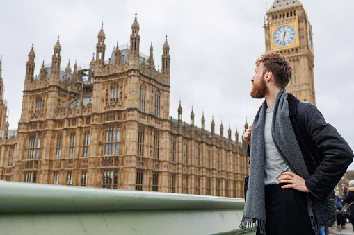 Bearded male tourist looks away against the background of the London clock tower