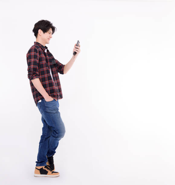 istock Young Asian student standing and watching smart phone 1472468002