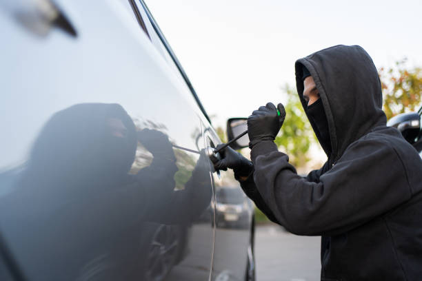istock Man trying to smash a car in a parking lot 1472468128