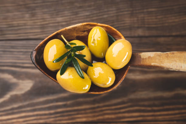 olives in  spoon and wooden background - olive oil pouring antioxidant liquid imagens e fotografias de stock