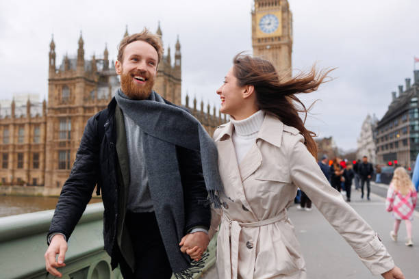 счастливая молодая пара гуляет, держась за руки, на фоне лондонского биг-бена - couple autumn embracing bridge стоковые фото и изображения