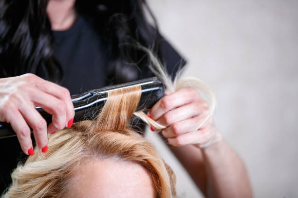 istock Making curls with iron at the hairdresser's 1472473823