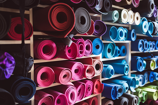 Yoga mats lying rolled up on shelves in exercising facility