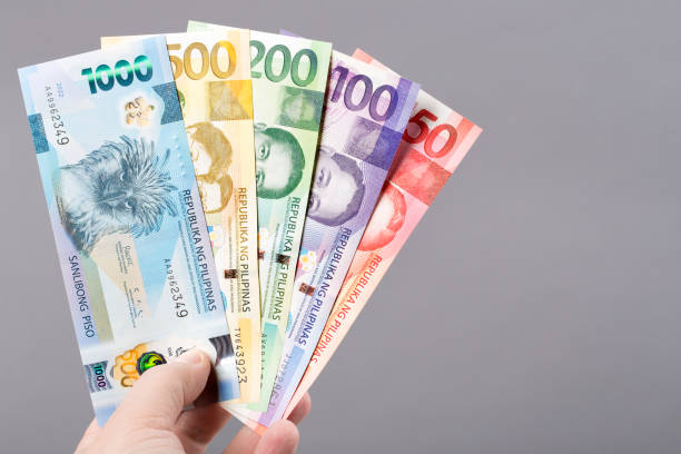 Philippine money on a gray background Philippine money - peso on a gray background philippines currency stock pictures, royalty-free photos & images