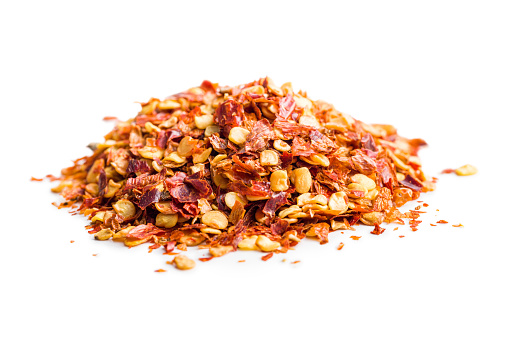 Dry chili pepper flakes. Crushed red peppers isolated on the white background.