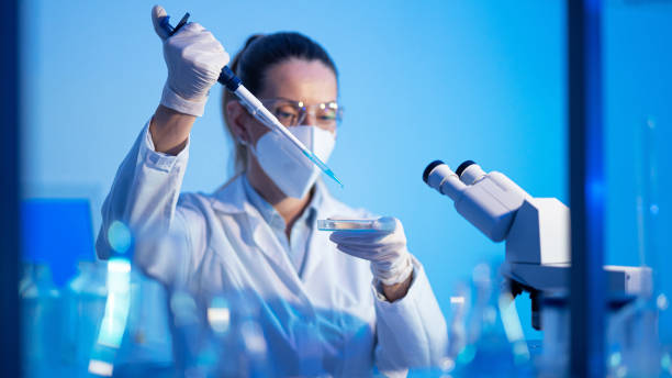 istock Female research scientist is analysing a sample on her microscope in a microbiology lab 1472478476