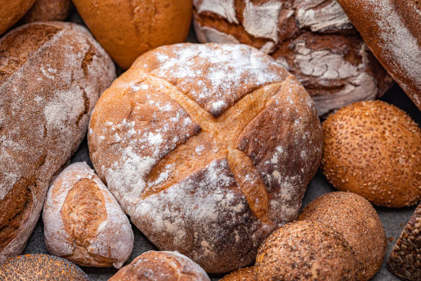 istock Freshly baked natural bread is on the kitchen table. 1472478515