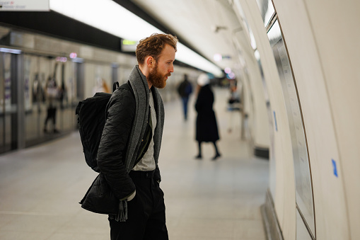 Bearded man looks at a subway train map