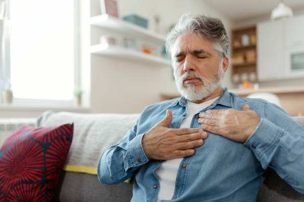 Chest Pain Male suffering from bad pain in his chest heart attack at home - heart disease male chest pain stock pictures, royalty-free photos & images